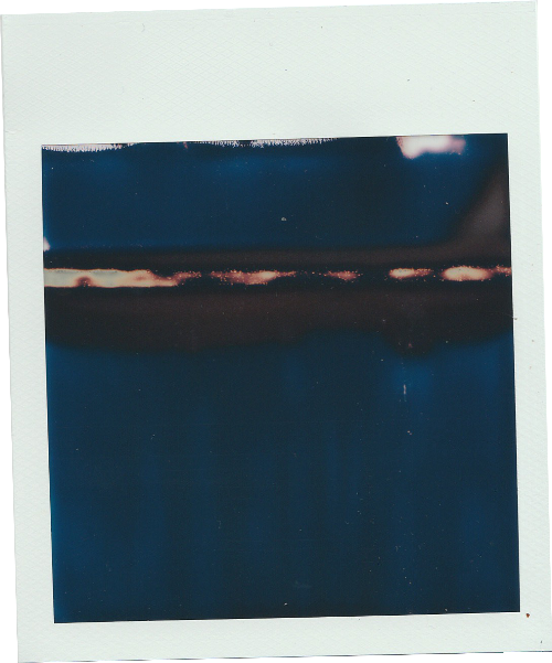 a photo of a blue polaroid with a black background